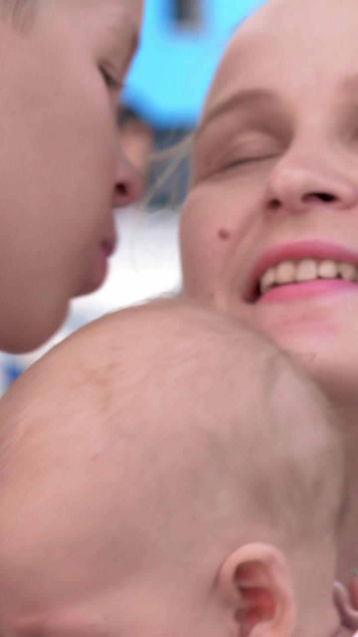 Ragazzo che bacia la sorellina e la mamma