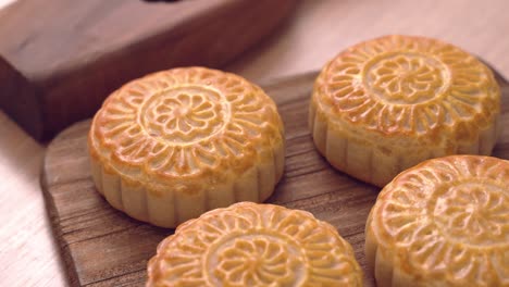 baked cantonese moon cake pastry on a wooden tray for traditional chinese mid-autumn festival.