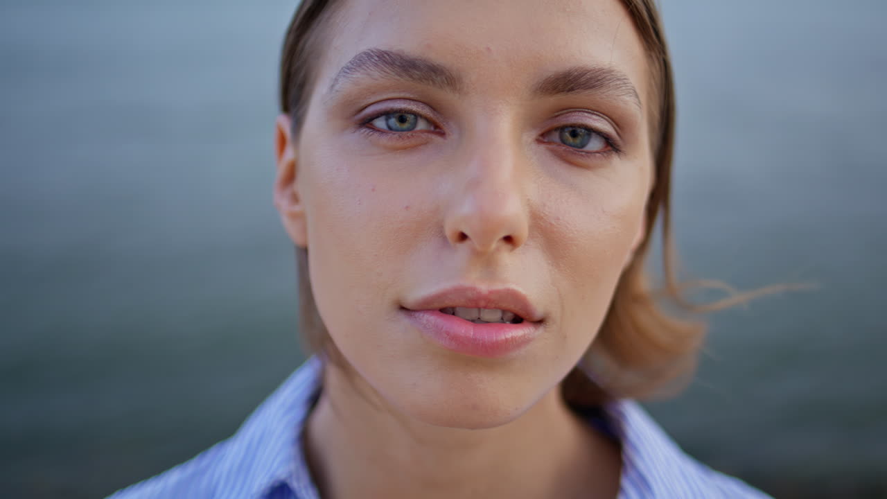 Closeup woman face posing by sea. Portrait brunette feeling serene