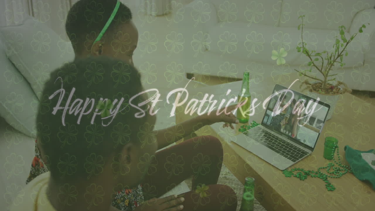 Happy st patricks day text and clover leaves against couple having video call on laptop at home