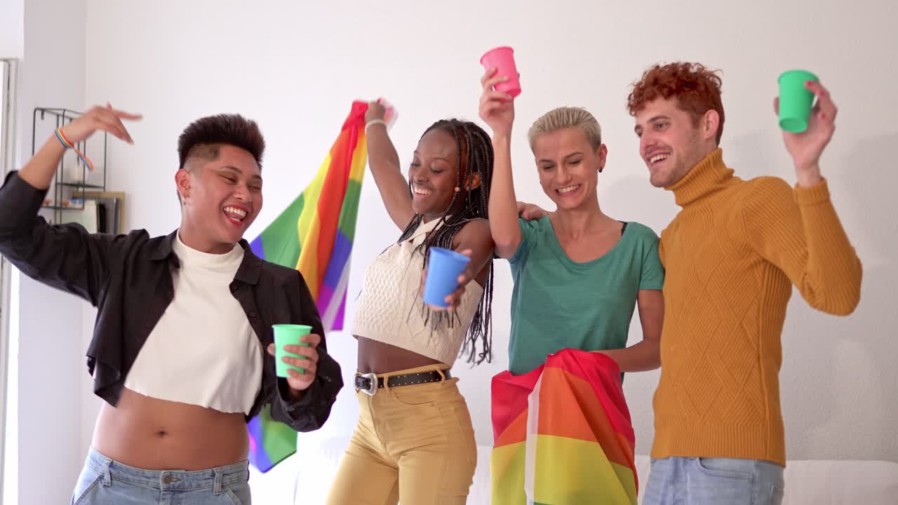 Diverse friends celebrating and dancing with a rainbow flag at a social gathering
