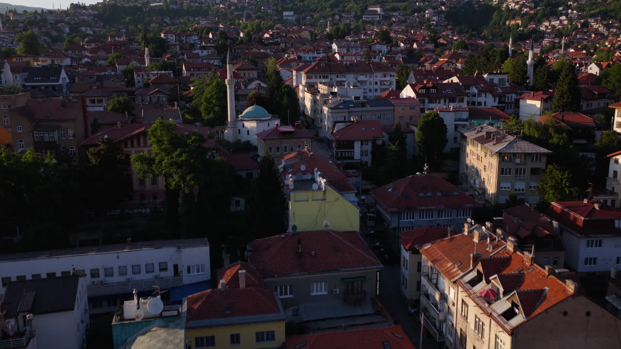 Toàn cảnh thành phố Sarajevo cổ kính lúc hoàng hôn với những ngọn tháp của nhà thờ Hồi giáo và những ngôi nhà. Góc máy nâng dần từ trên không