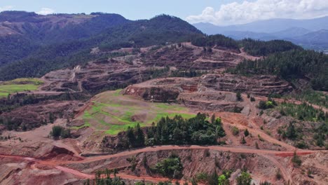 aerial forward flight towards falconbridge mine plant in dominican republic during summer - mountain landscape in backdrop