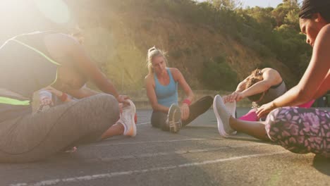 diverse female basketball team wearing sportswear, stretching