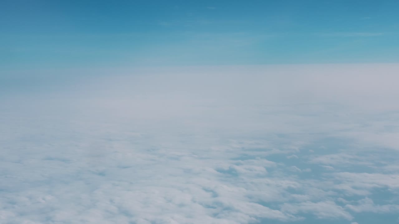 traveling on a plane and looking out from the window to see the blue sky and cloud at the horizon moving shot in 4k