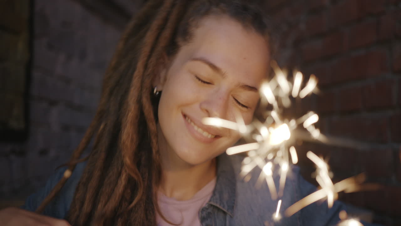 Smiling woman holding a sparkler