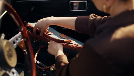 woman in a vintage car, preparing a travel bag