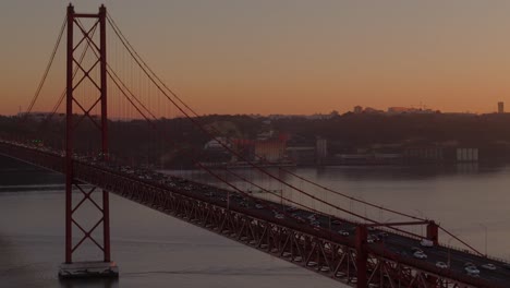 Orange-Dämmerung-Glühen-Verbreitet-Sich-über-Autos-Pendeln-Auf-Hängebrücke-In-Lissabon,-Portugal