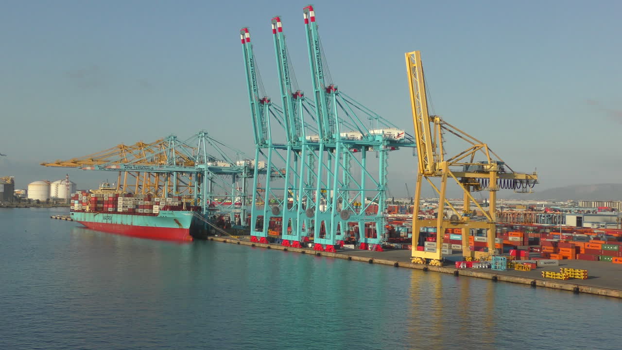 There are many containers and cranes in the port of Barcelona