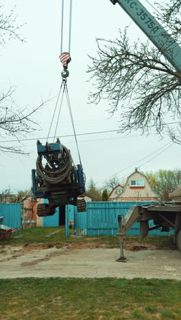 a crane lifting a machine for well drilling. preparation for the boring of the water pore in the rural area. vertical video.