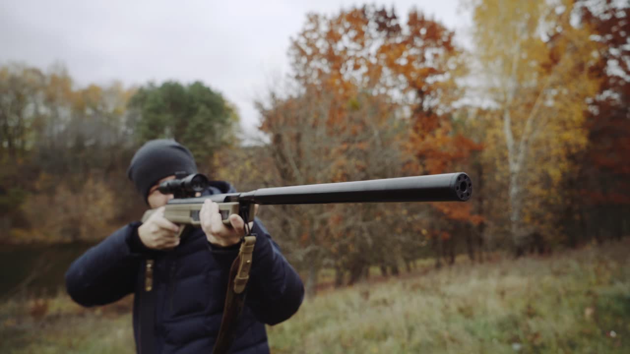 Man aiming with hunting rifle. Hunter man looking through the scope of hunting rifle