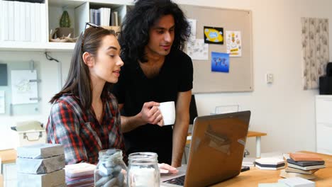 Executives-discussing-over-laptop