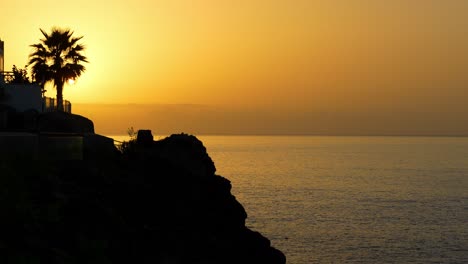 sunset sky with silhouette coastal cliffs and ocean views at los gigantes, tenerife, canary islands