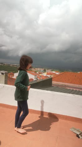 girl dancing on rooftop during cloudy weather