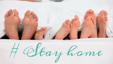 animation of the words ~ stay home over four pairs of bare feet in bed at home.