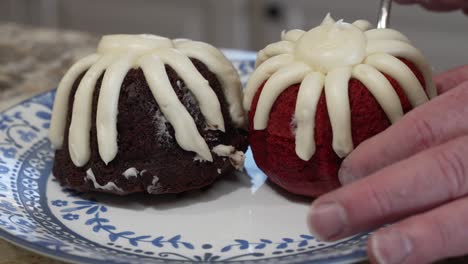 placing a red velvet cupcake on a plate with a chocolate muffin - parallax motion