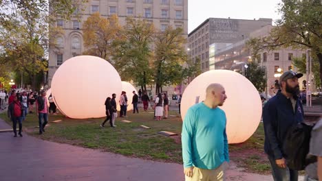 daytime crowd at nuit blanche winnipeg views blue and purple glowing art balls