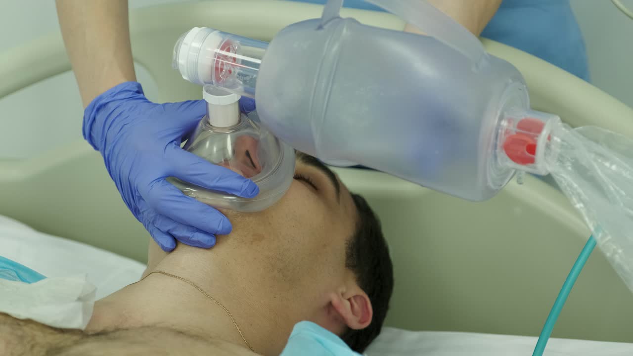 los médicos hacen reanimación a un paciente masculino en la sala de emergencias. masaje cardíaco. desfibrilación.