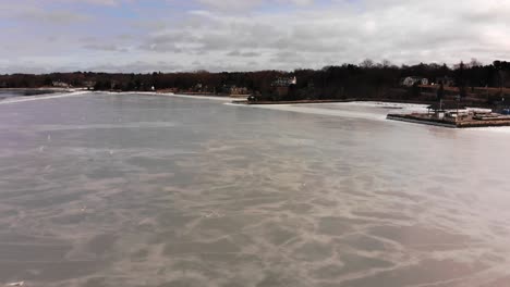 long low advancing aerial of ice frozen on shore of hingham harbor