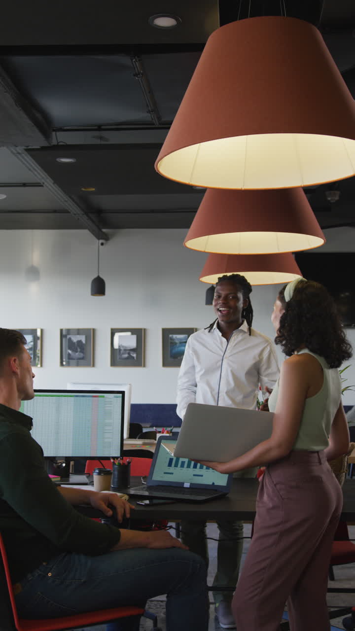 video vertical de personas de negocios felices y diversas discutiendo el trabajo durante una reunión en la oficina