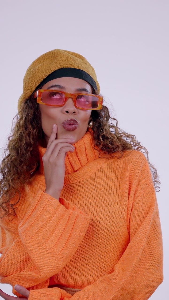 Stylish Young Woman Posing and Thinking in Orange Sweater