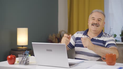 home office worker old man dances looking at camera.