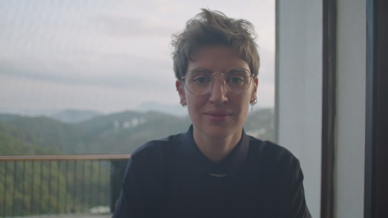 Ritratto di giovane donna al bar con vista sulle montagne