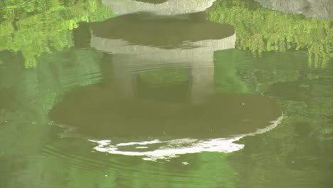 Reflexion-Einer-Japanischen-Schneelaterne-Im-Teichwasser