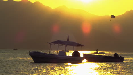 sunset view of subic bay olongapo city, philippines with speed boat, parasailing and jet ski in the background