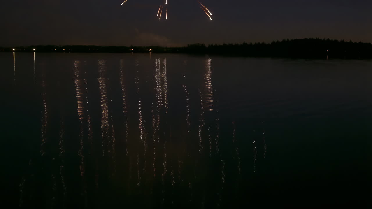 Fireworks Reflecting on Dark Water at Night