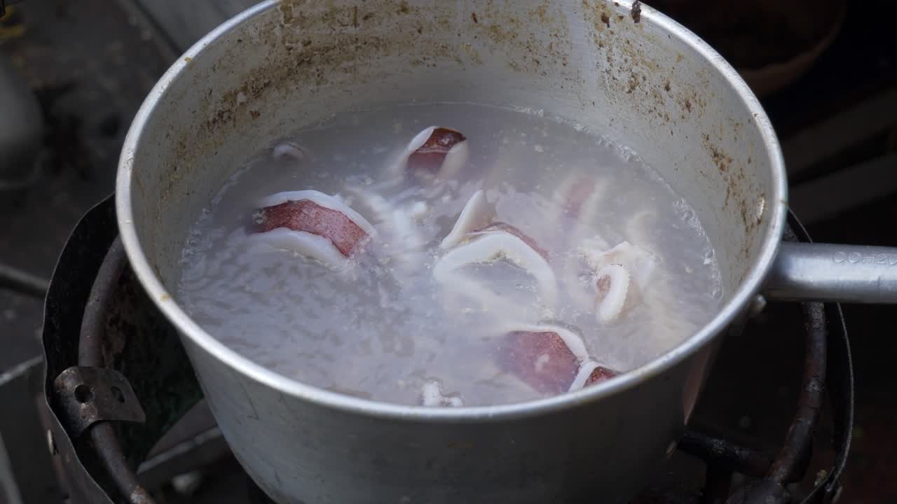 Koking av blekksprut i vann på en gatematrestaurant