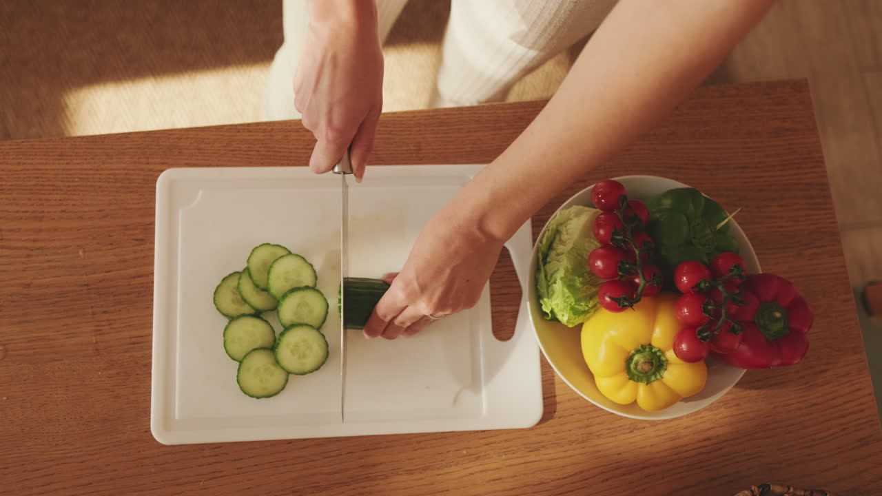 Woman Slicing Cucumber for Salad Preparation