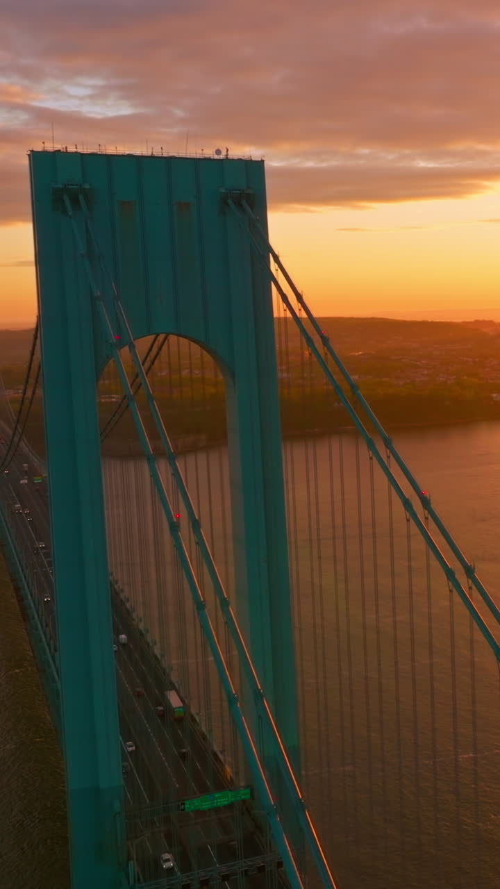 Fantastic big setting sun over East River. Blue Bronx Whitestone bridge with many cars moving quickly. Aerial view. Vertical video