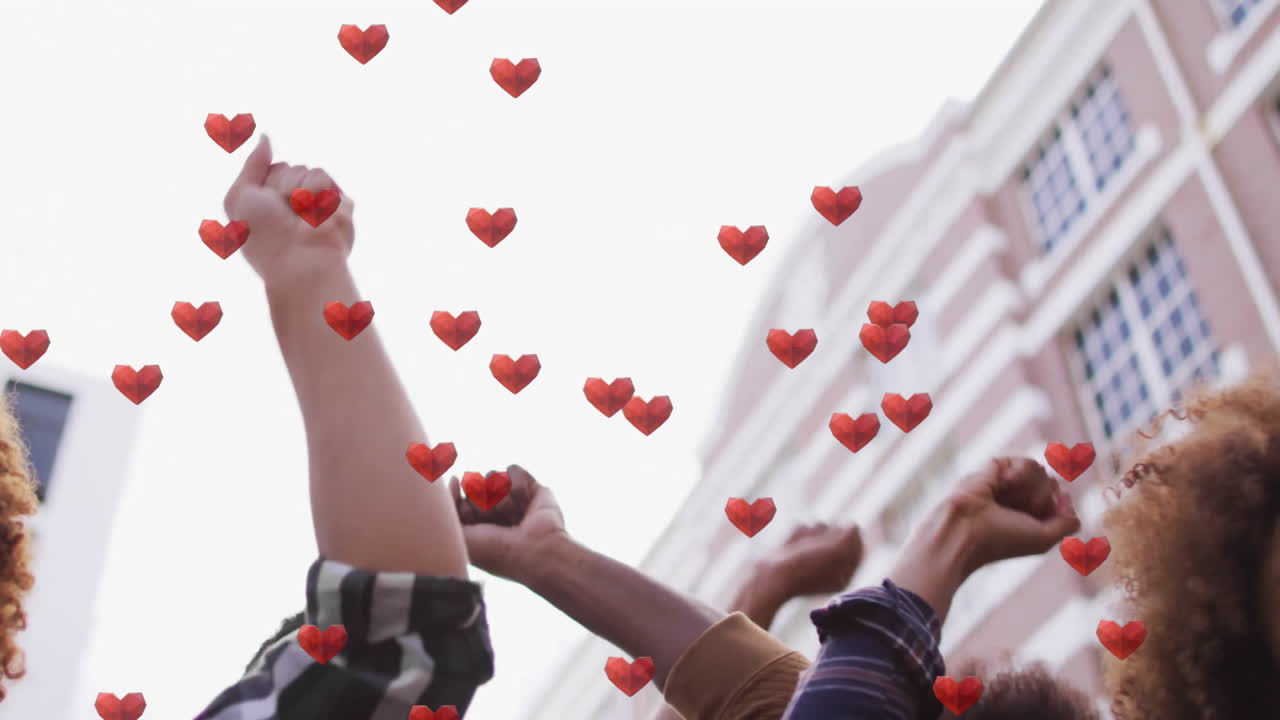 Activists standing on urban street, raising fists in activism, showing floating hearts overlay