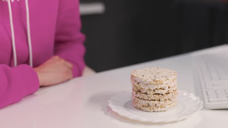 close up of an unrecognizable woman eating rice crackers