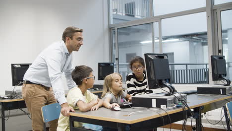 Teacher-with-pupils-having-fun-during-computer-science-lesson