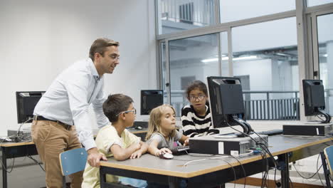 profesor con alumnos divirtiéndose durante la lección de informática