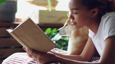 woman reading a book with her dog