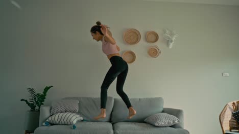 happy woman jumping on sofa