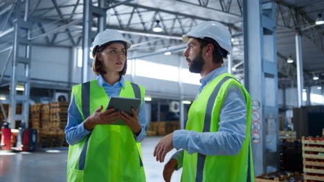 factory workers discussing tablet information analysing production process