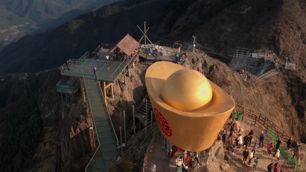 유리 다리 위를 걷는 관광객들과 함께 산꼭대기의 경치 좋은 곳 위를 날다