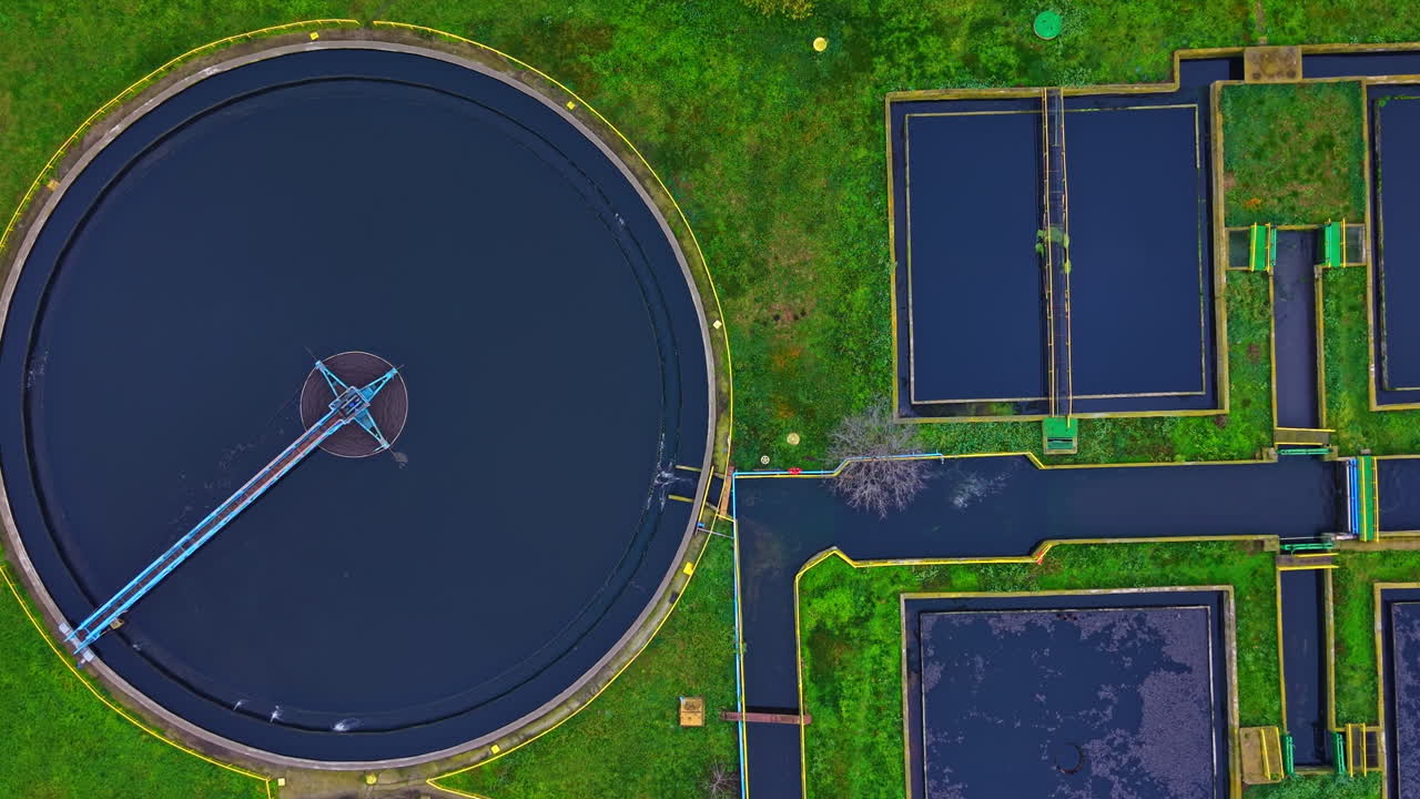 Water treatment facility located in a green area showing tanks and roads during daylight hours