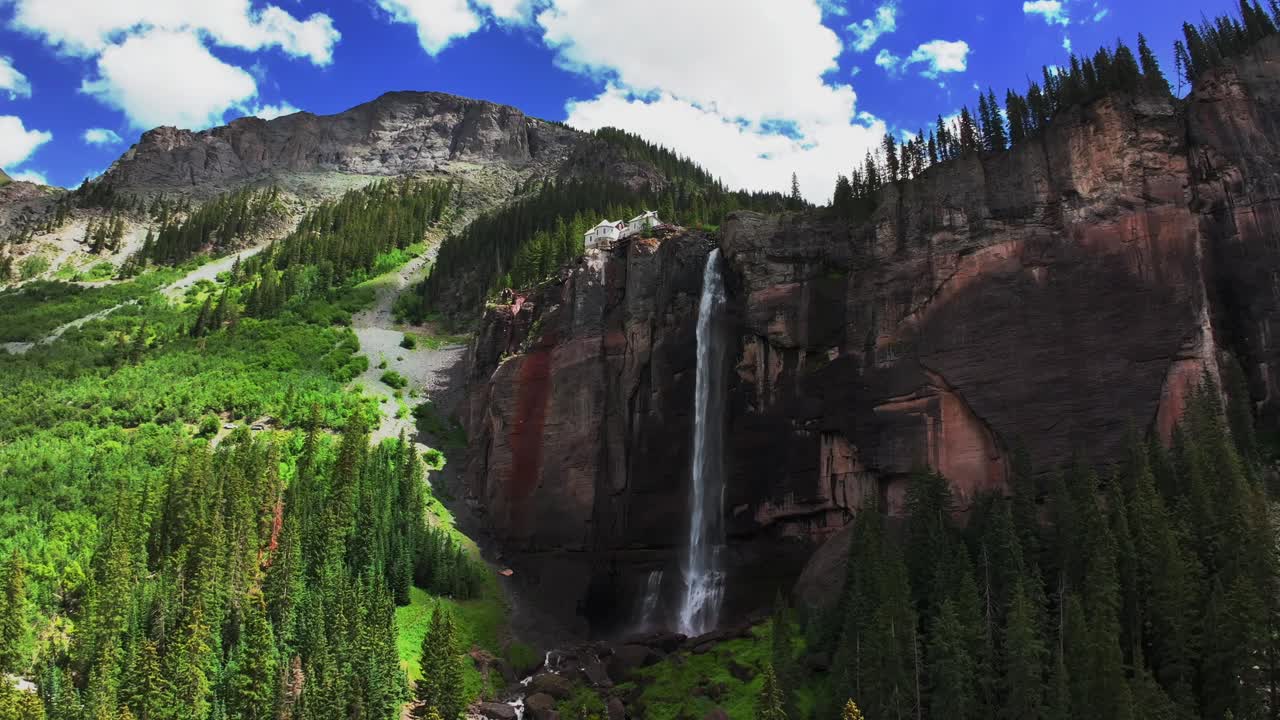 Telluride Bridal Veil Falls Waterfall Colorado powerplant house aerial drone sunny summer green Box Canyon Black Bear Pass Road Rocky Mountains 4wd blue sky cliffside Uncompahgre Forest circle left