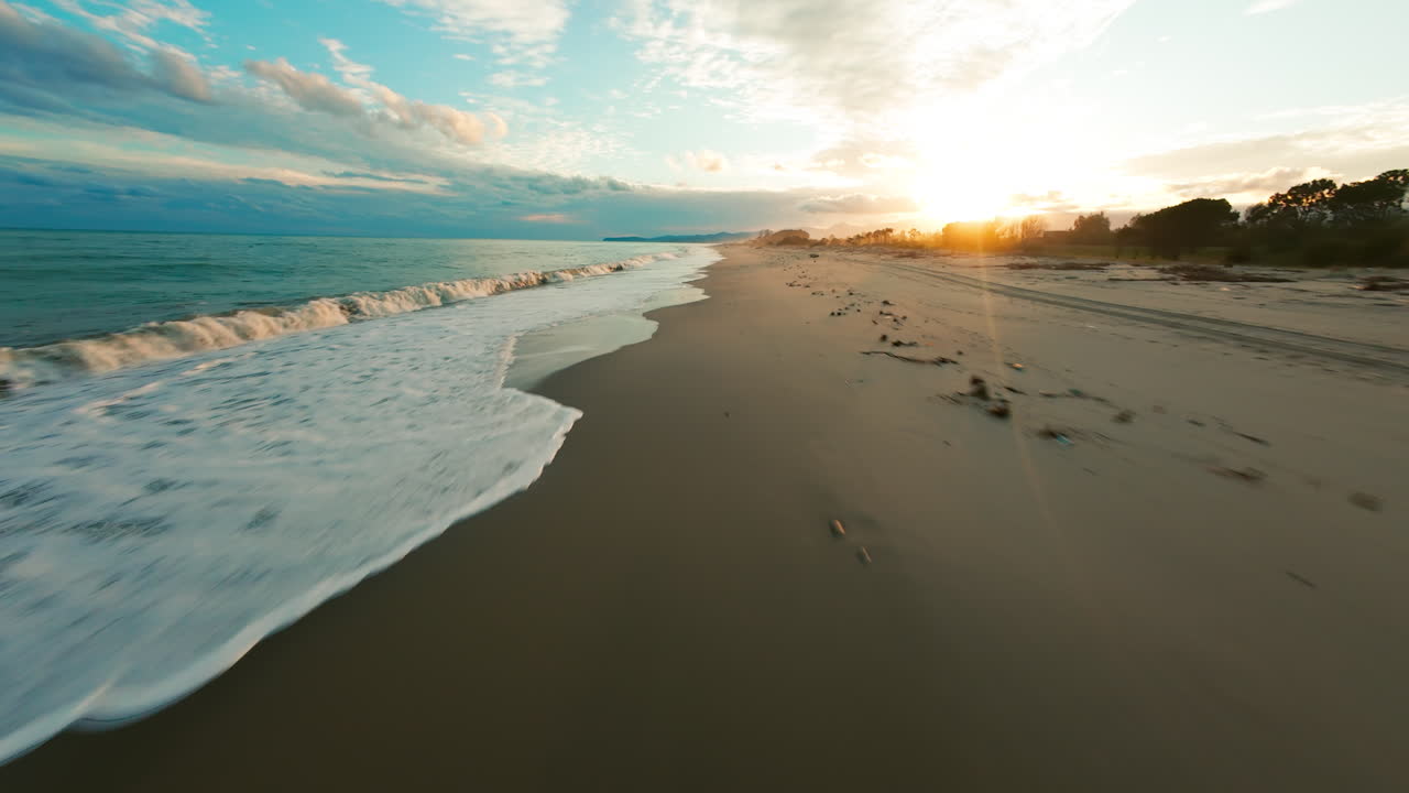 costa arenosa con olas tormentosas del océano y sol al amanecer
