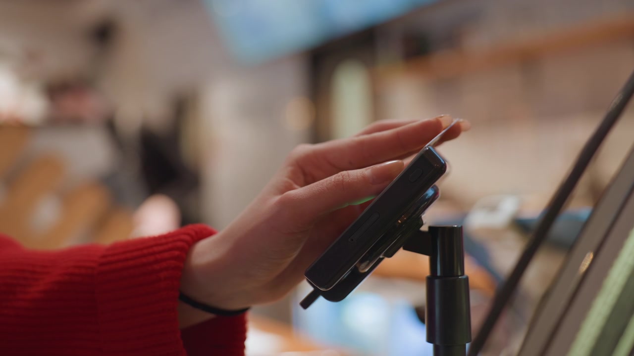 Customer Making Contactless Payment with Credit Card at a Terminal
