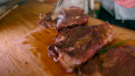 view of a man arranging the slices of smoky hot steak on a wooden table