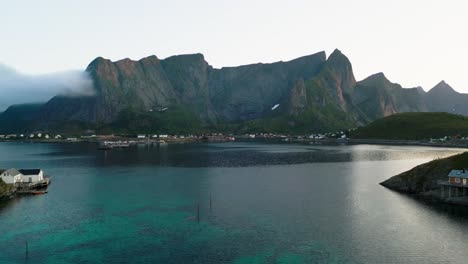 An-aerial-perspective-captures-the-distant-mountains-in-the-Lofoten-Islands,-Norway,-where-the-sunset-delicately-touches-the-tips-of-the-mountain-peaks