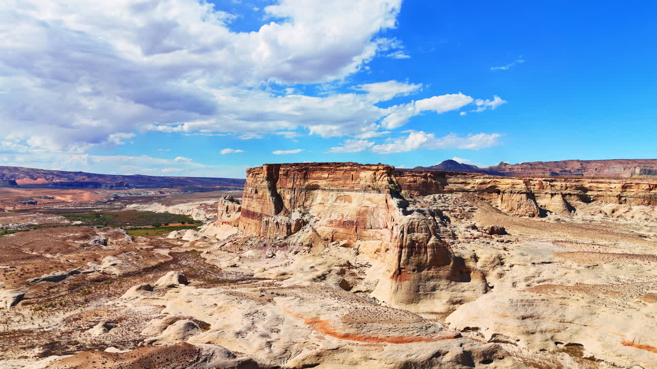 Clip video di un paesaggio desertico e arido con canyon meravigliosi. Incantevoli nuvole bianche e soffici nel cielo azzurro. Lone Rock Campground, Utah, USA