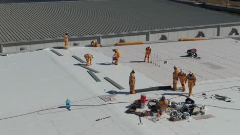 people waterproofing an industrial rooftop