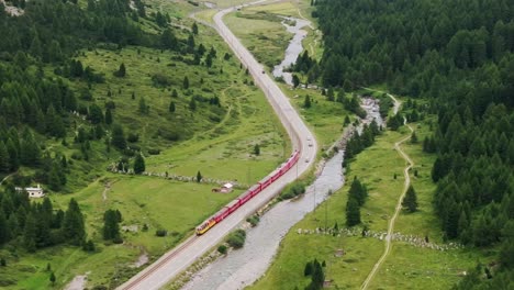 train travels through swiss alpine valley - overcast summer day, lush scenery